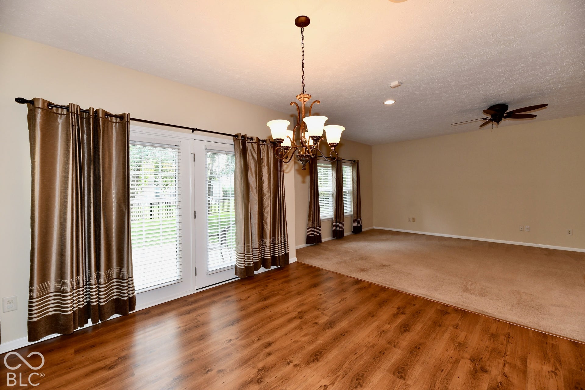 Dining area looking onto Living Room with wood-finish flooring and carpeted areas