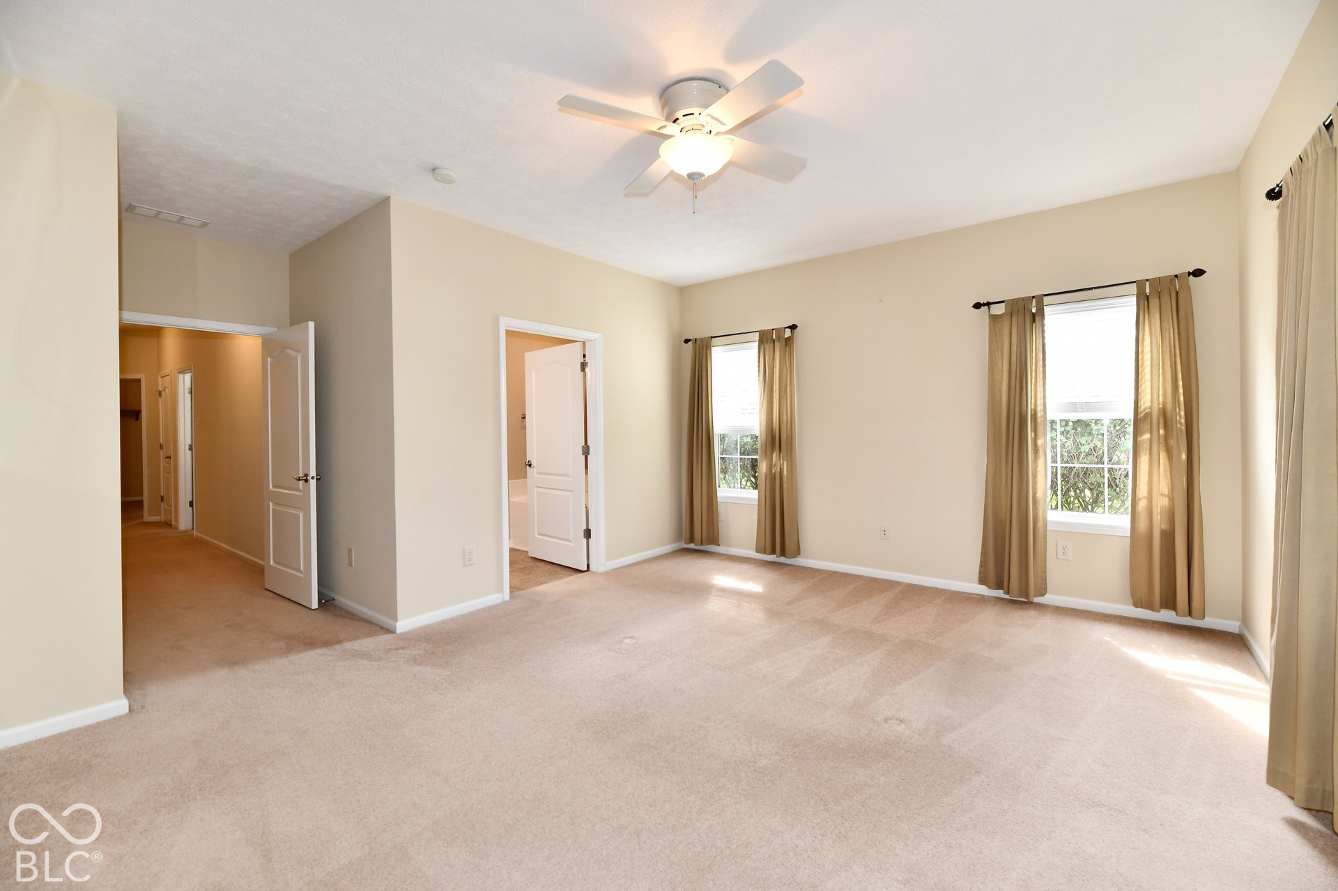 Spacious Primary Suite - large windows with abundant natural light, ceiling fan, carpeted
