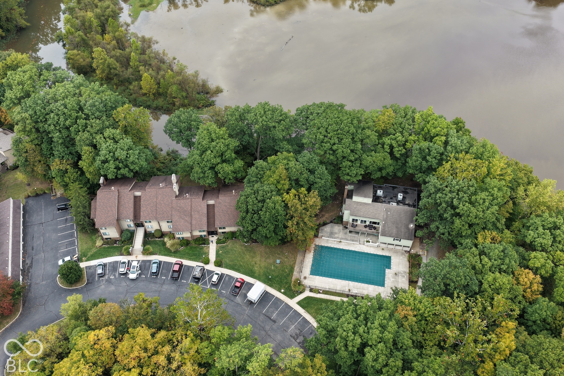 201 Bluffs Circle, Noblesville, IN 46062 Body of water framing the property, wooded surroundings, multi-unit residential building, swimming pool, and dedicated parking areas