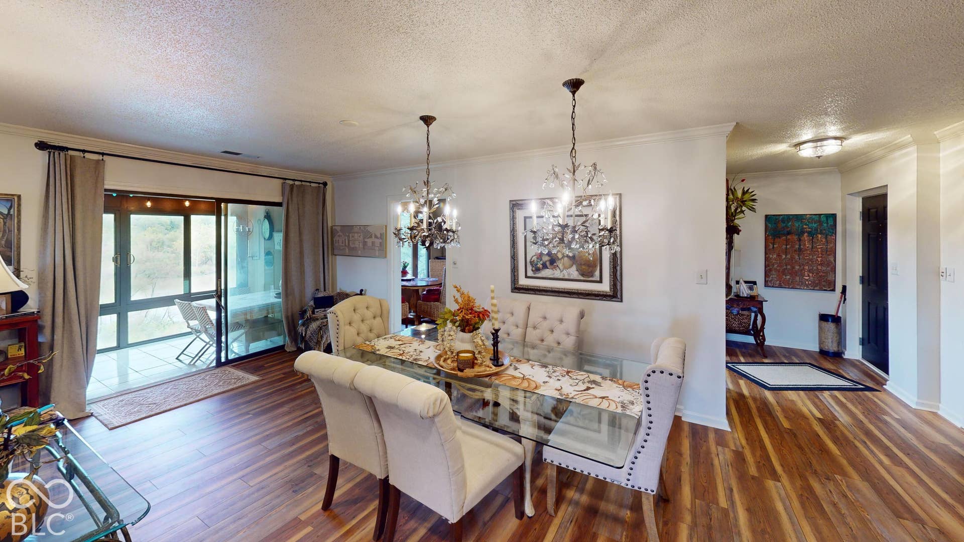201 Bluffs Circle, Noblesville, IN 46062 Wood-finish flooring, white wall paint, two crystal chandeliers, sliding glass doors to outdoor area, and a built-in ceiling light fixture
