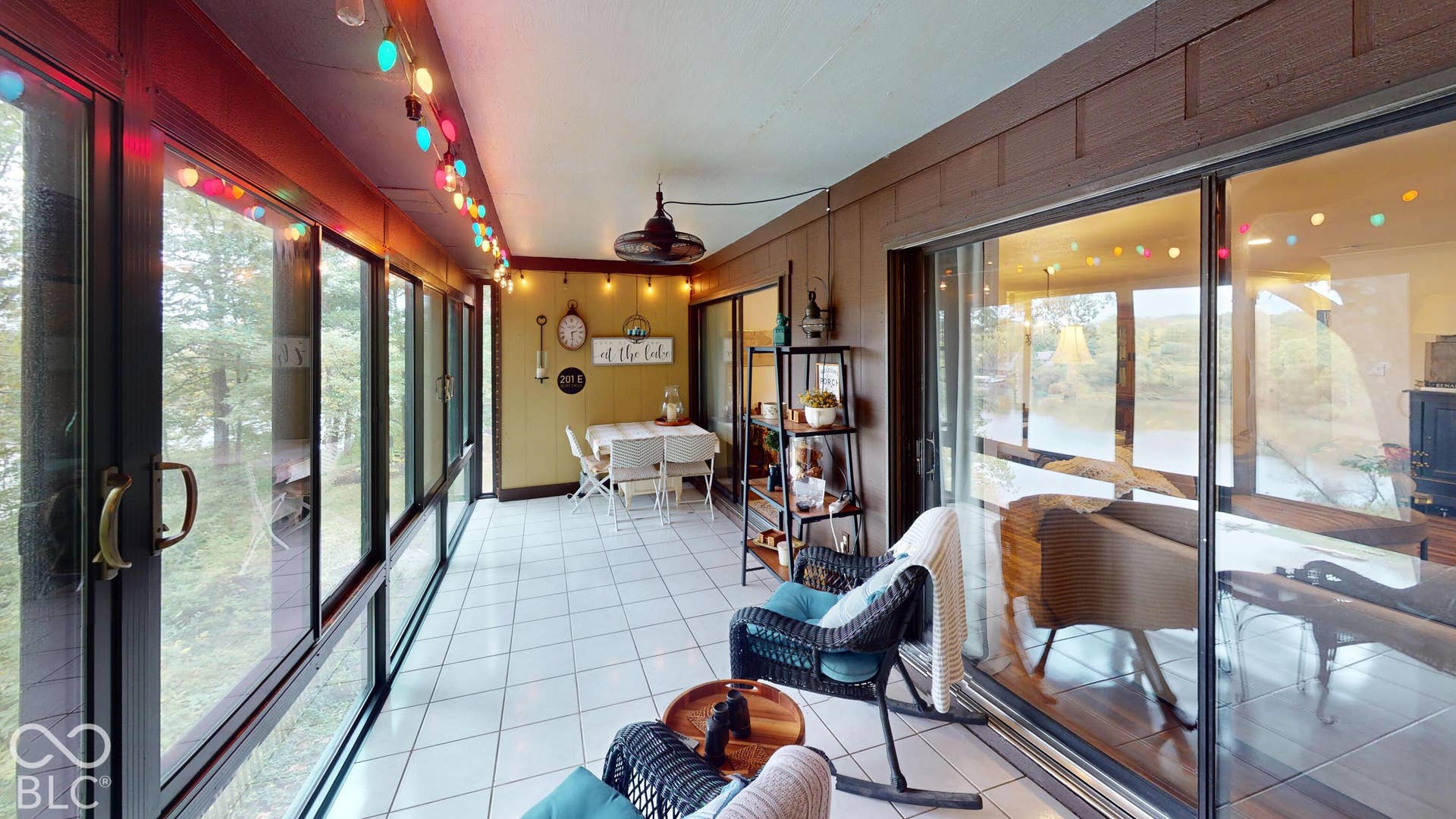 201 Bluffs Circle, Noblesville, IN 46062 Enclosed sunroom featuring white tile flooring, a dark wood-paneled ceiling, and expansive windows