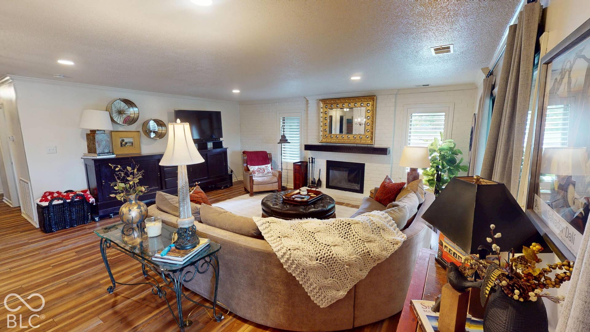201 Bluffs Circle, Noblesville, IN 46062 Wood-finish flooring, recessed lighting, white brick fireplace with dark wood mantle, plantation shutters, and crown molding