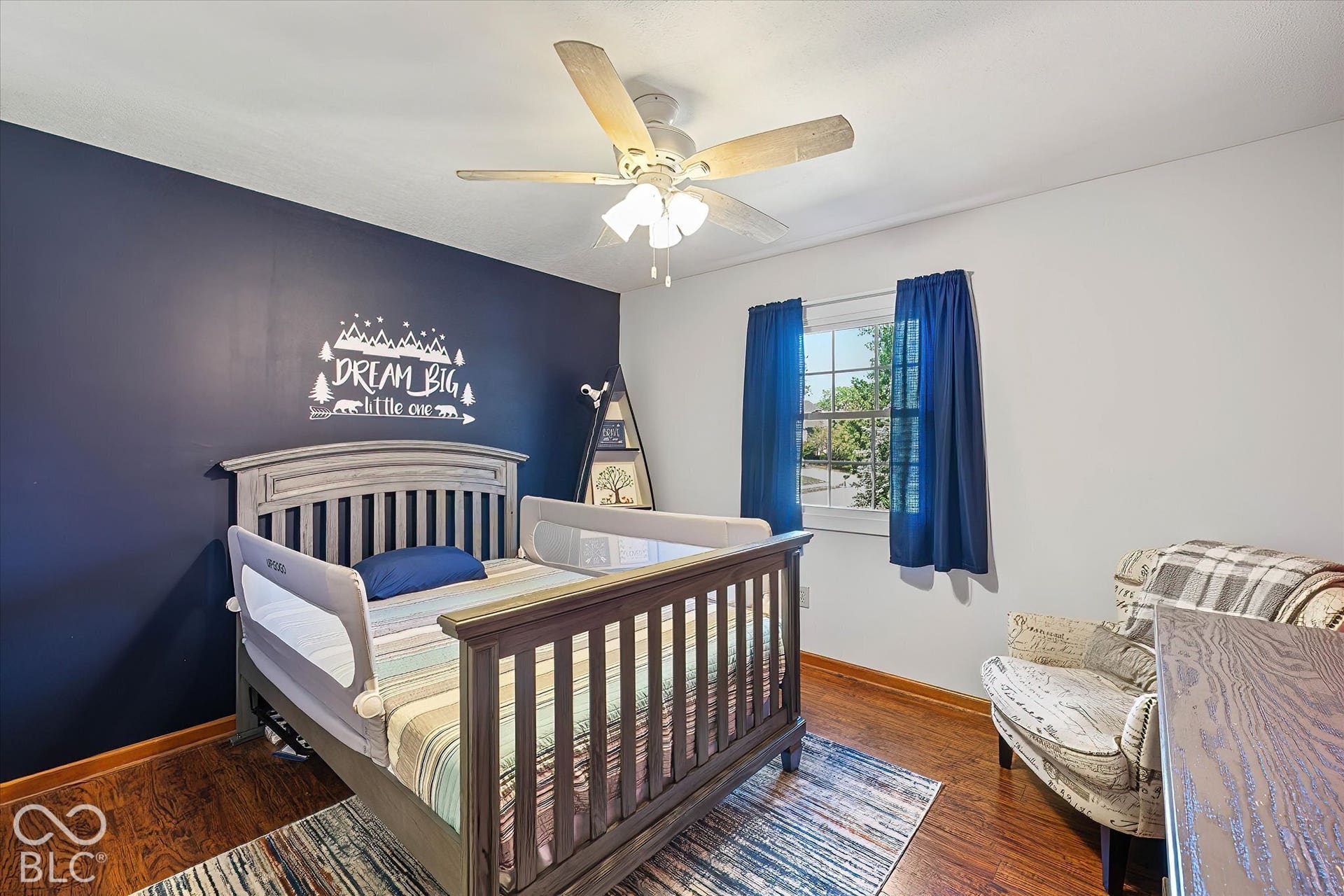 Bedroom w/ ceiling fan and accent wall.