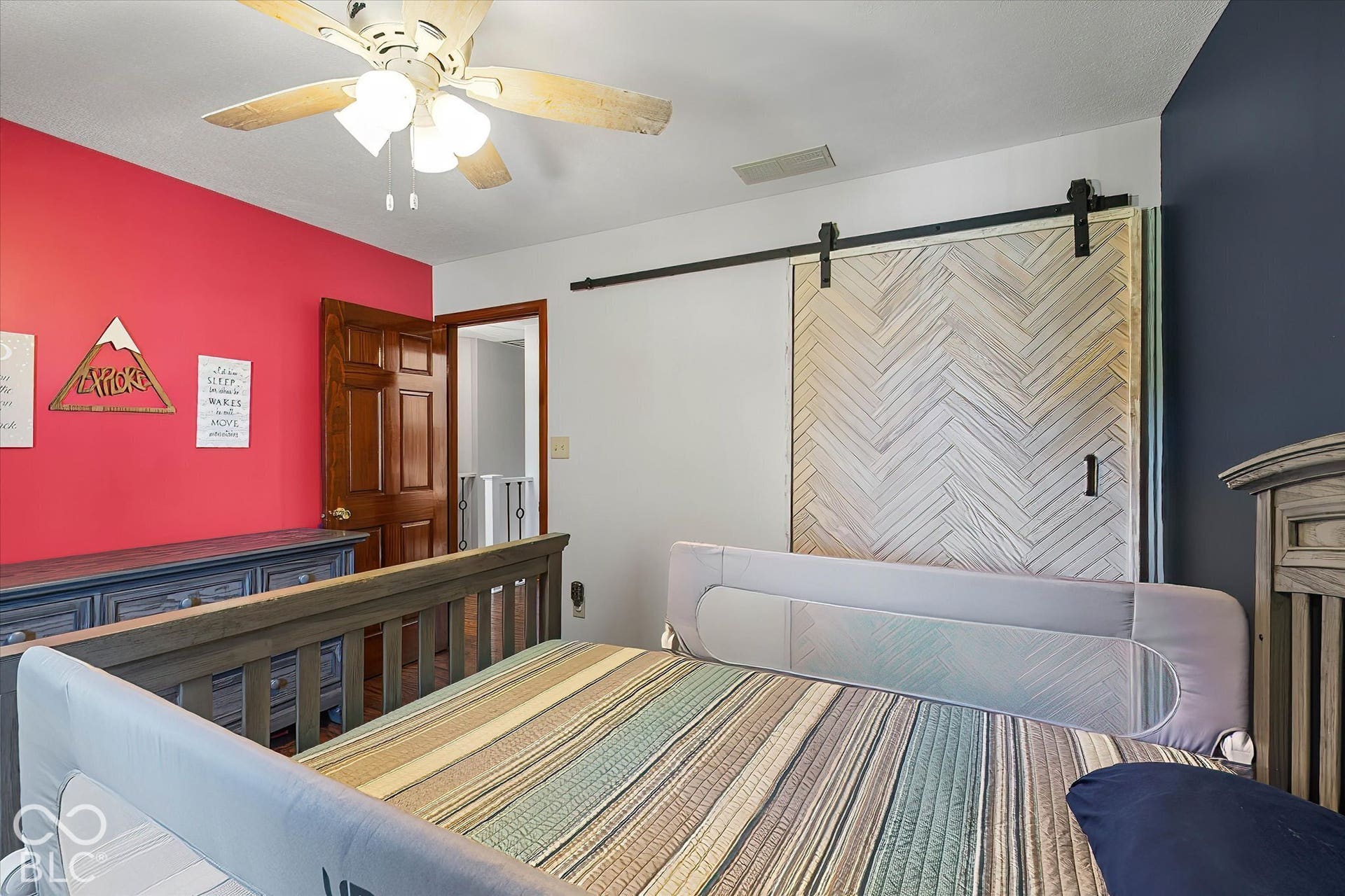 Bedroom w/ accent wall and custom barn door for closet.