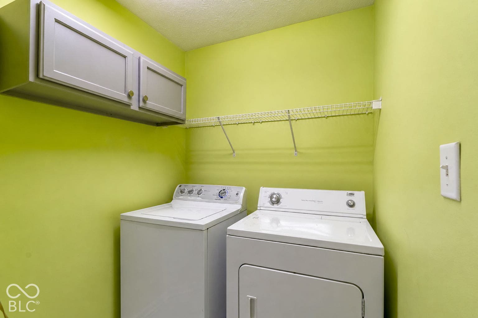 Upper cabinetry, wire shelving, and textured ceiling