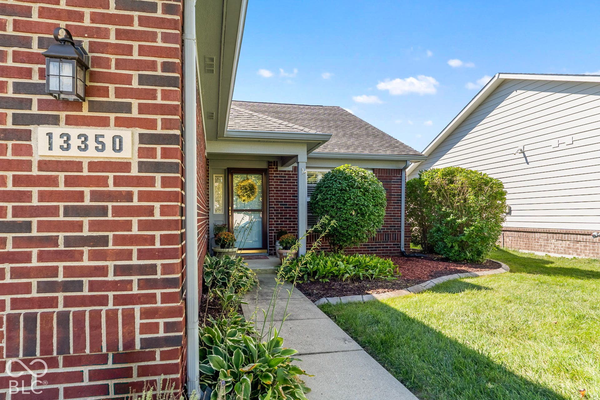 Brick exterior with exterior wall lantern and house numbers