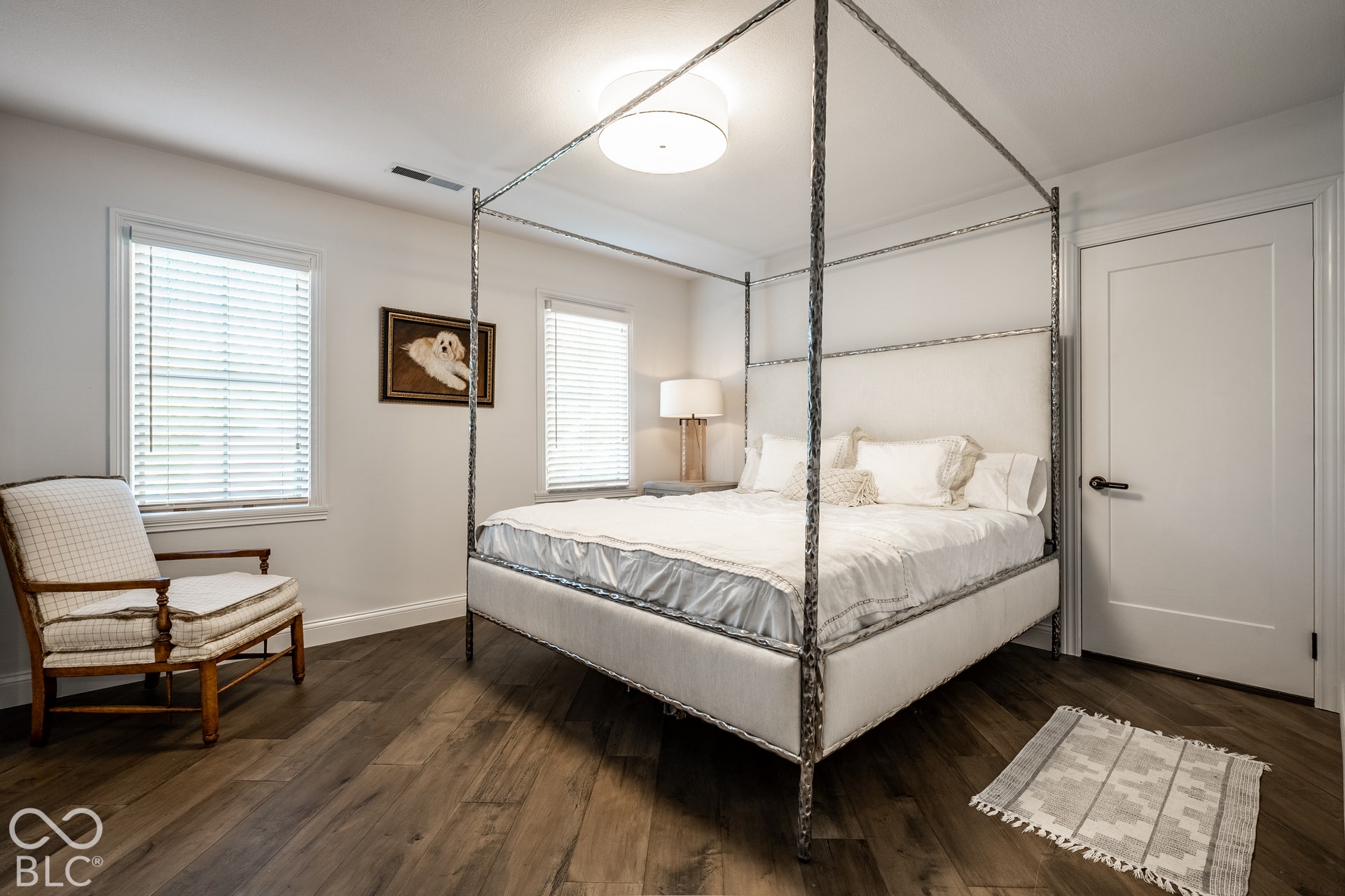 Wood-finish flooring, dual windows with blinds, and a flush-mount ceiling light