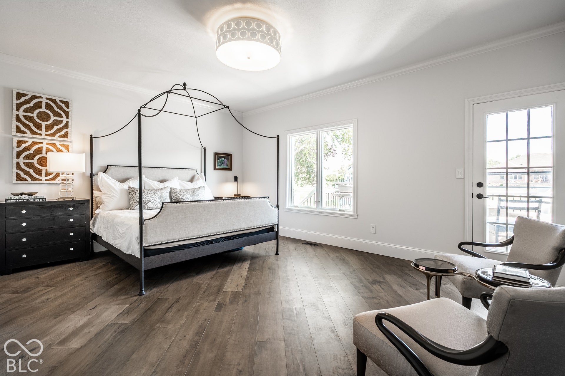 Wood-finish flooring, crown molding, and a drum-style ceiling light