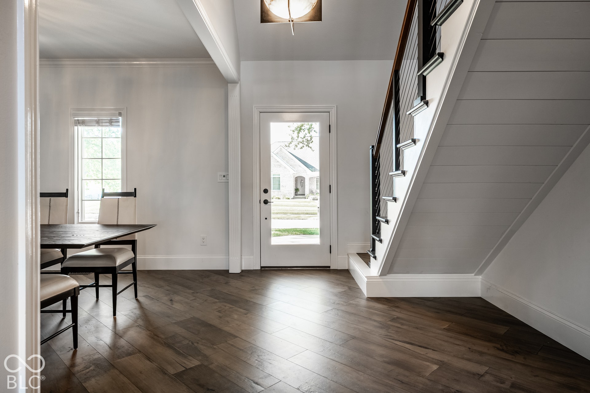 Wood-finish flooring throughout, bright white walls, contemporary cable railing, 7.5 inch trim, floating staircase, and a glass-paneled entry door