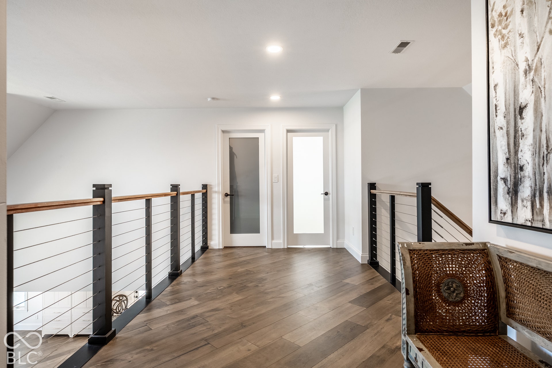 This loft area and the hallway features Herringbone wood-finish flooring.