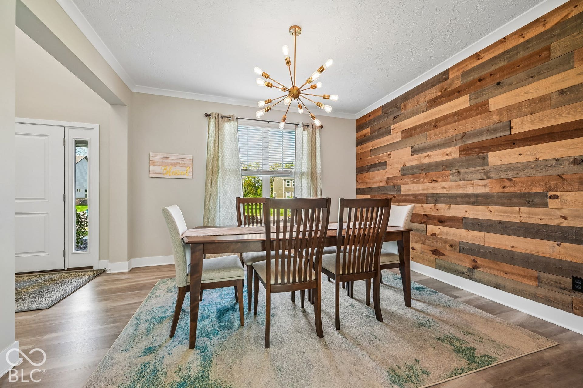 Accent wall featuring horizontal wood paneling, wood-finish flooring, and a contemporary chandelier