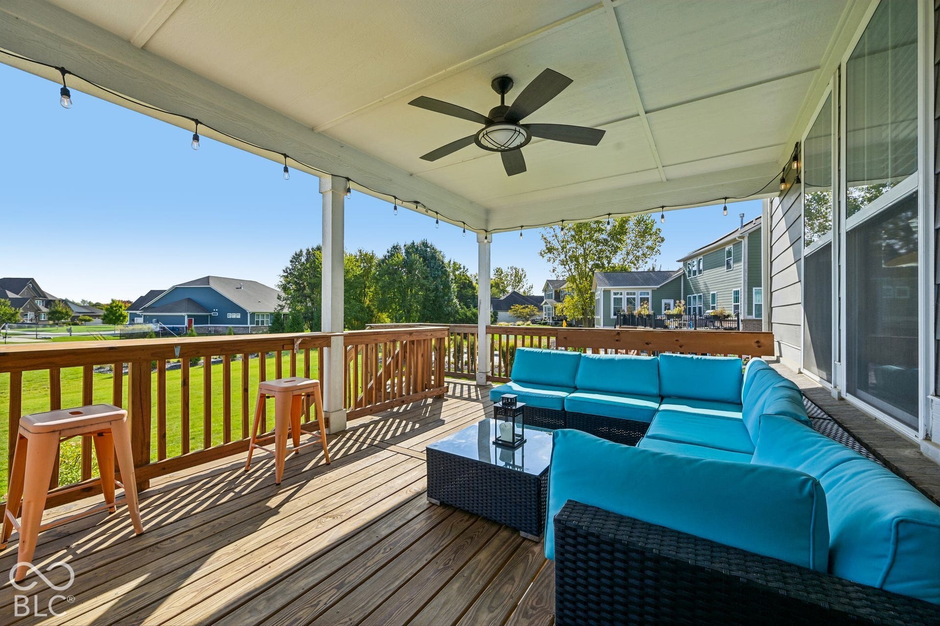 Expansive wood deck with a full roof cover, equipped with a ceiling fan