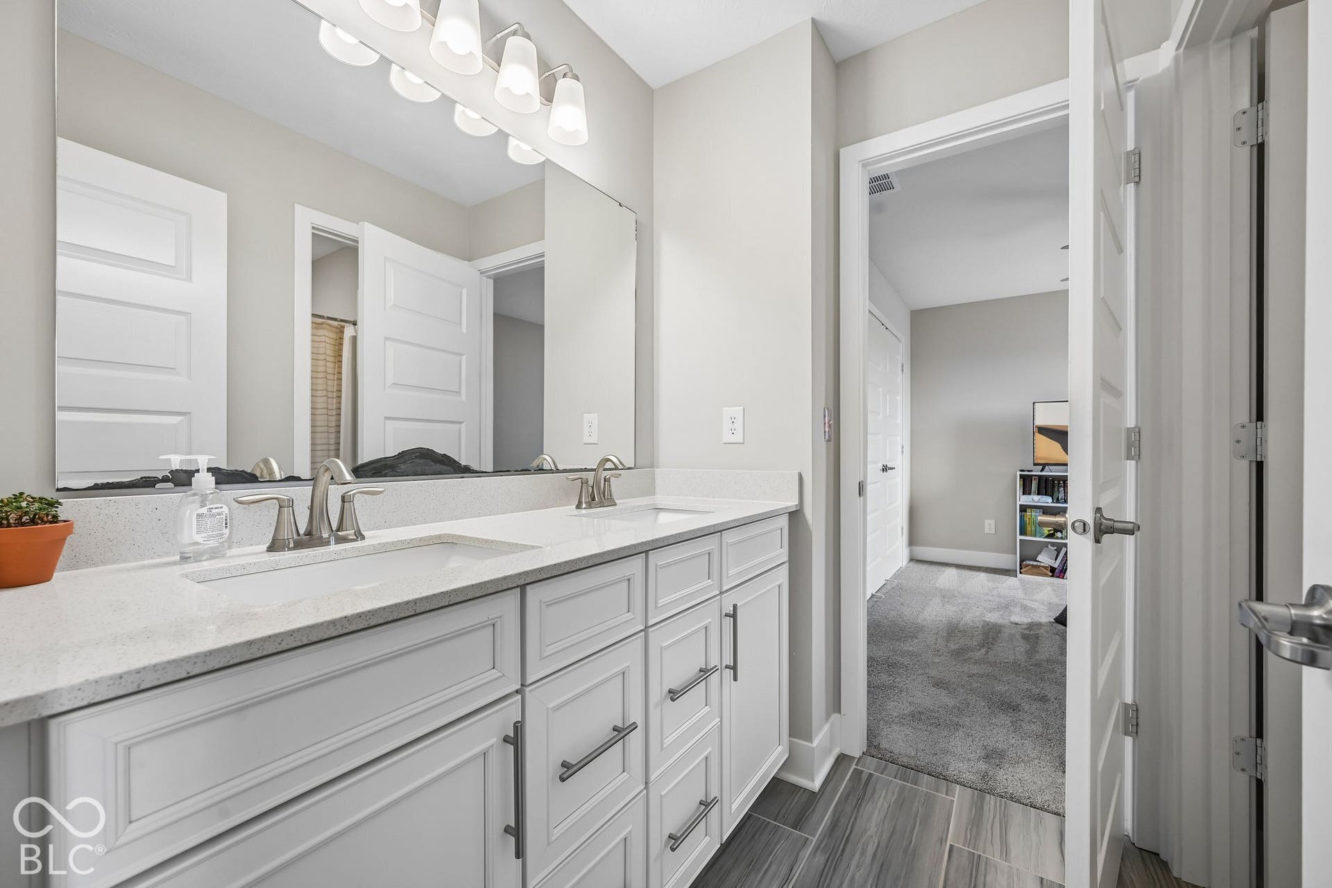 Dual vanity with white cabinetry, light-colored countertops, and brushed nickel fixtures
