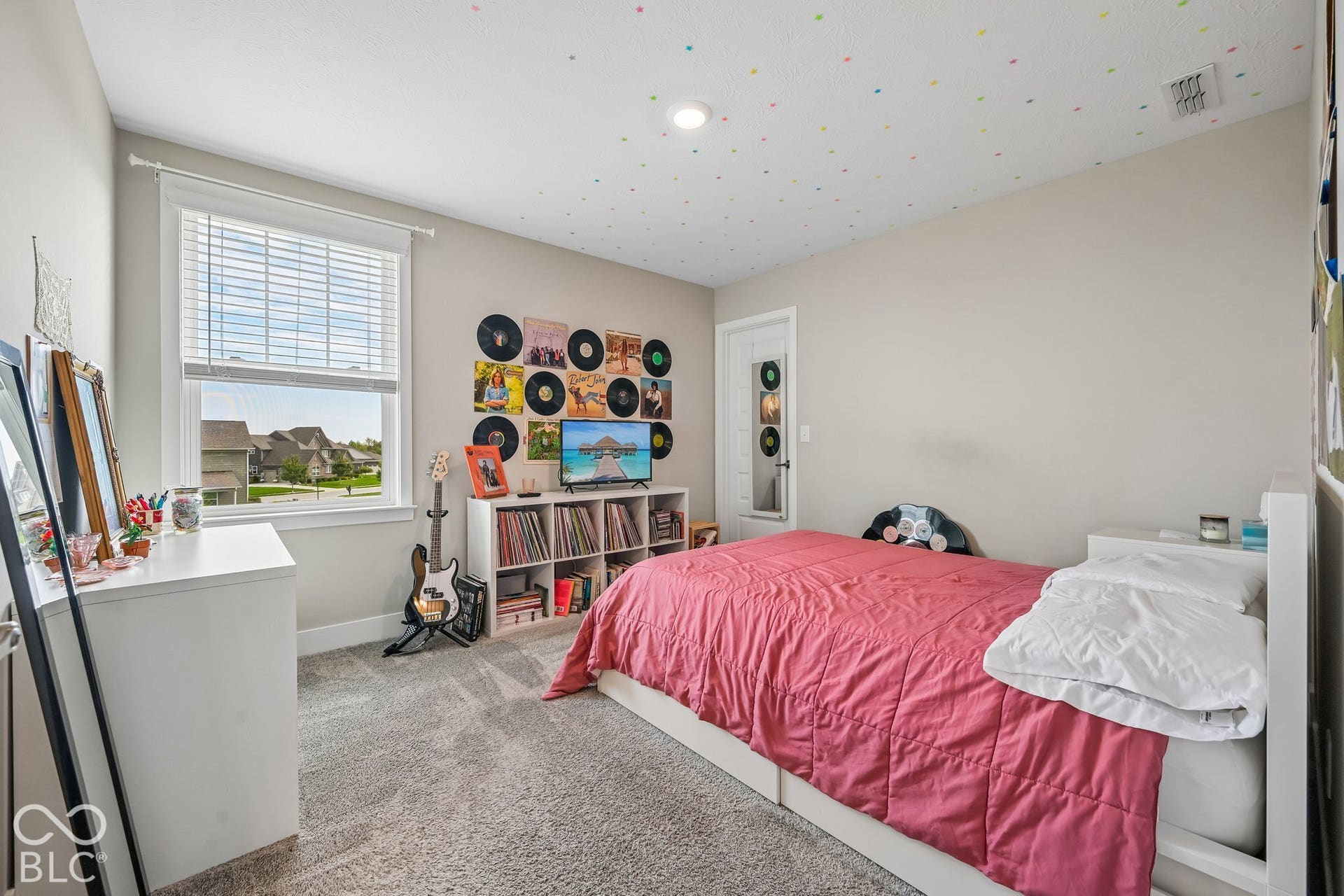 Window with blinds, wall-to-wall carpeting, overhead lighting, and painted walls