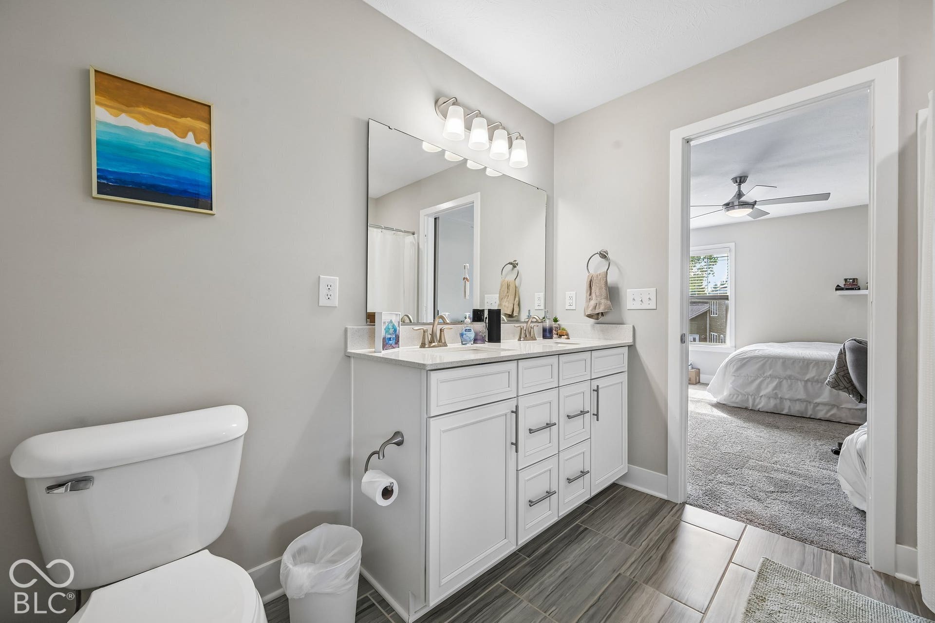 Dual vanity with white cabinetry, brushed nickel hardware, and a framed mirror