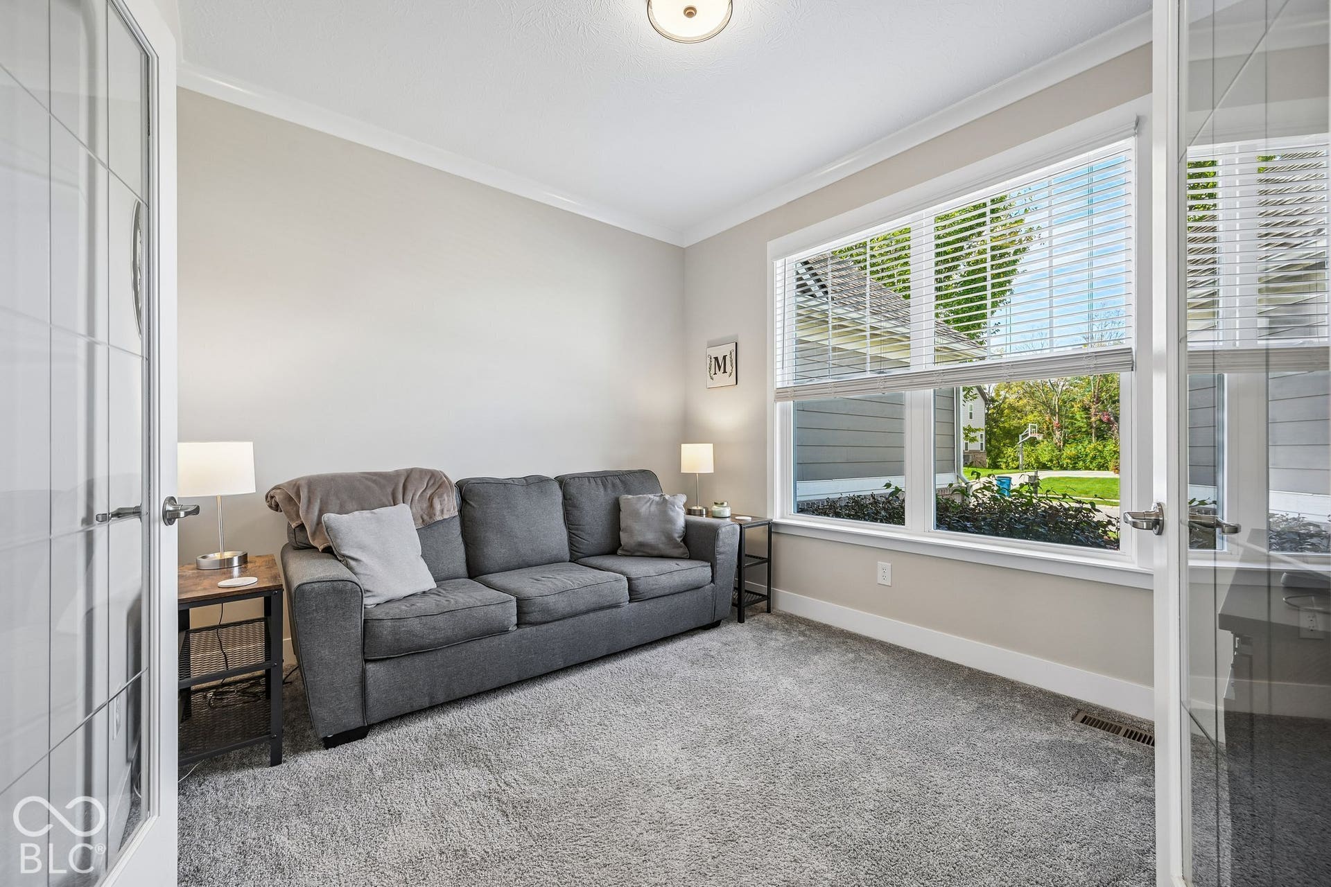 Recessed lighting, crown molding, and large window with blinds