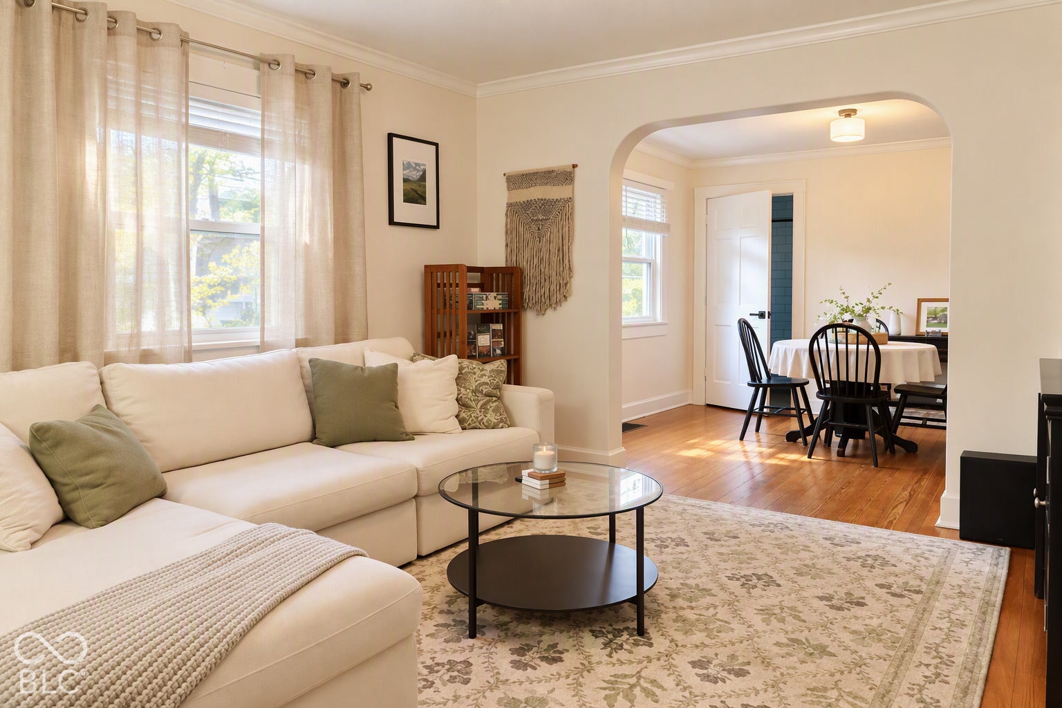 Hardwood flooring, arched doorway, and crown molding