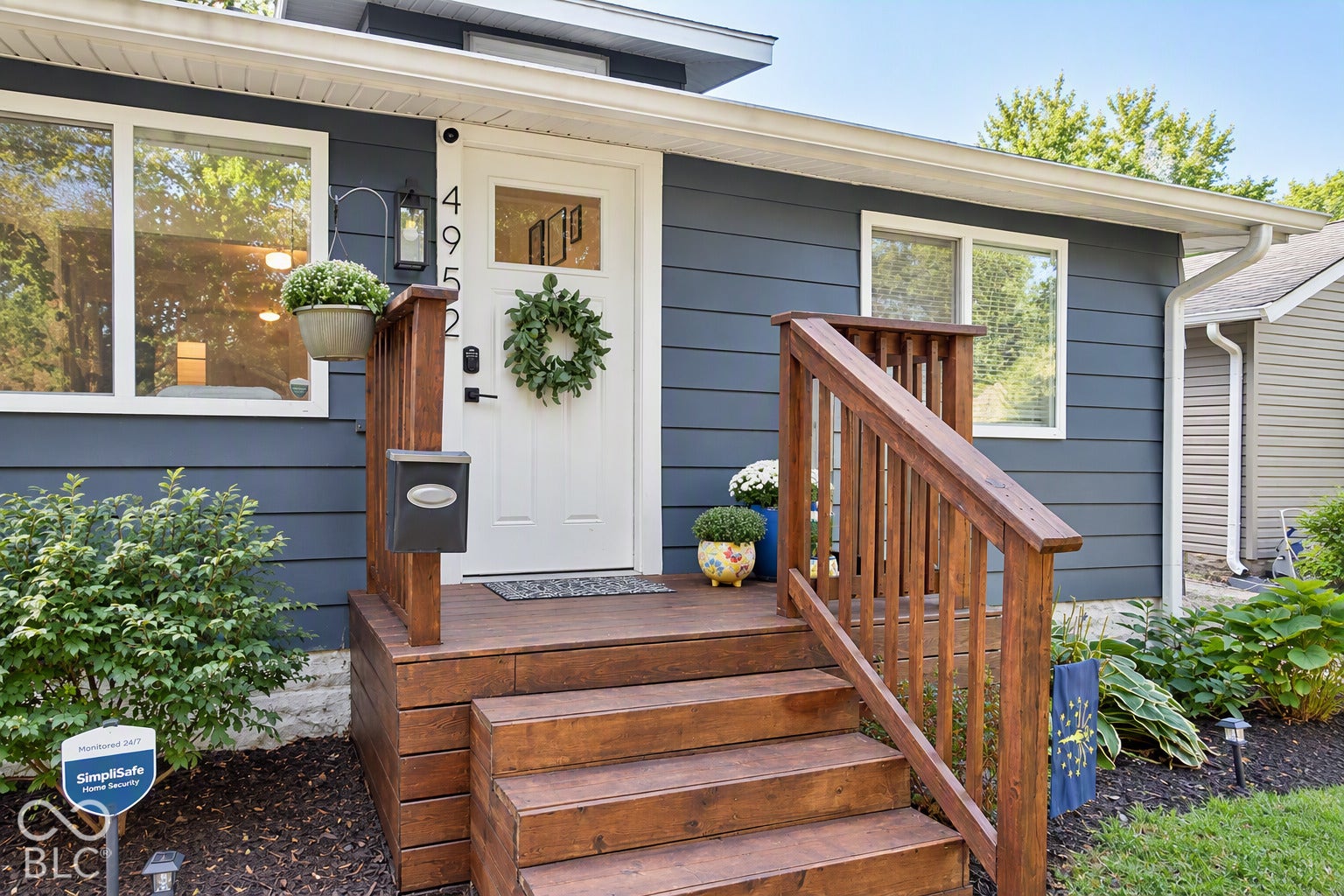Exterior featuring horizontal siding, white trim windows, a white entry door with a glass insert, and a wood-finish porch with railings