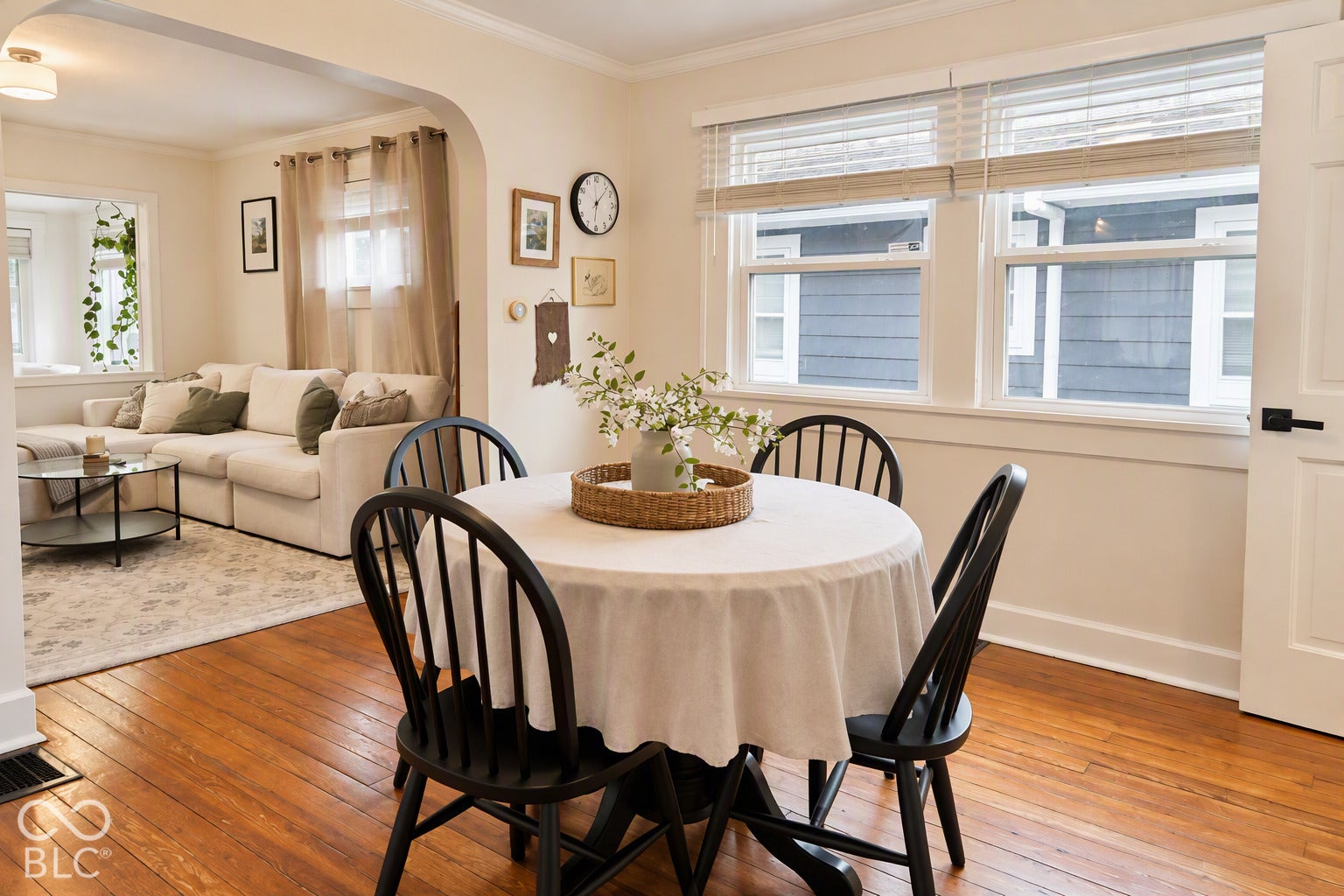 Hardwood flooring, arched doorway, recessed lighting, white trim, and multiple windows