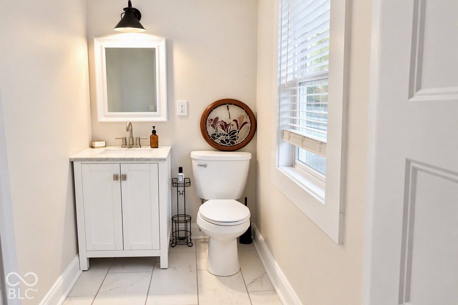 White vanity with a marble-finish countertop, undermount sink, and brushed nickel faucet