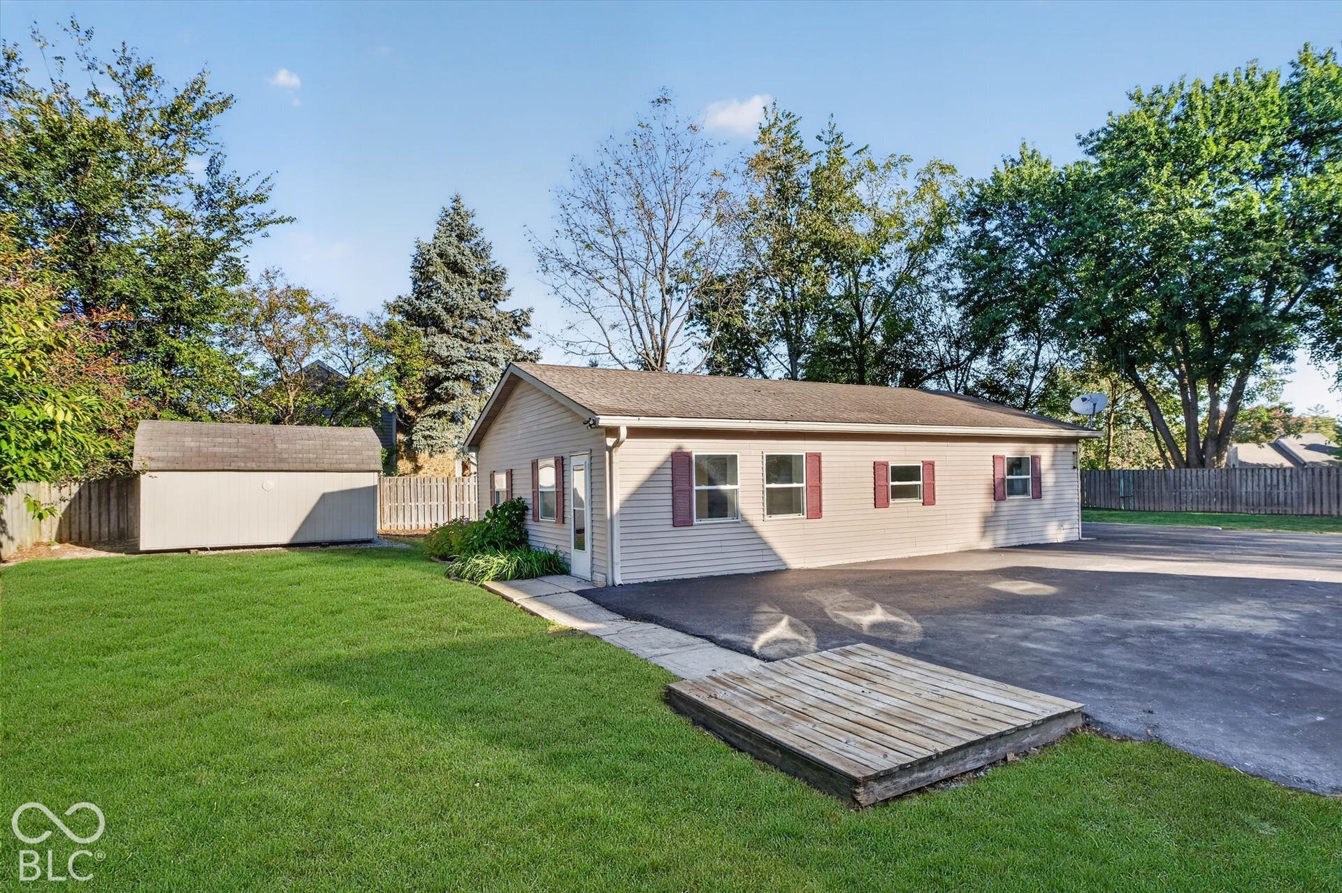 8404 Union Chapel Road, Indianapolis, IN 46240 Spacious paved parking area, vinyl siding, red window shutters, and a storage shed