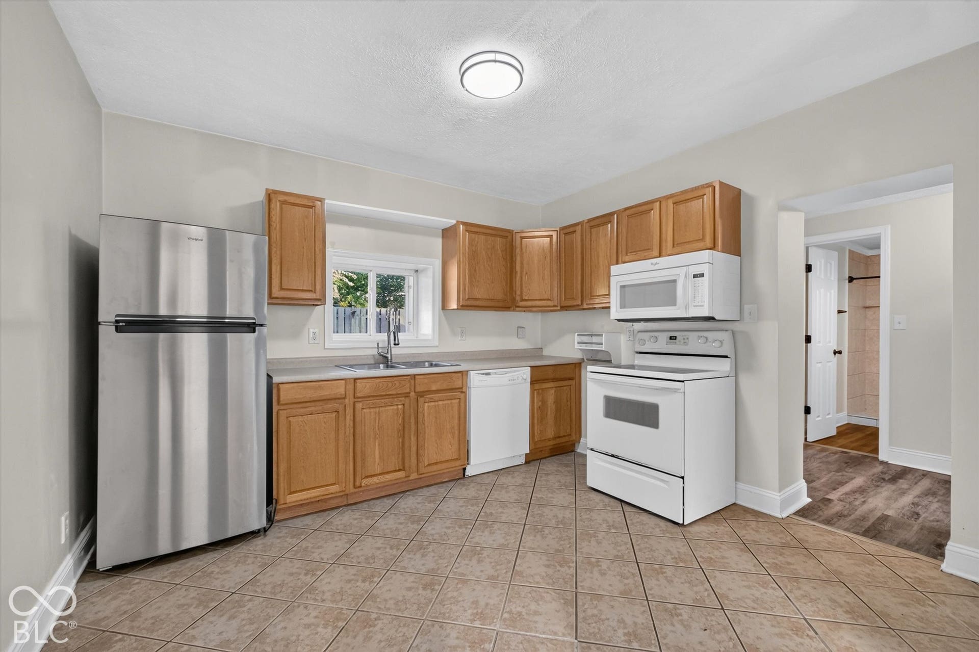 8404 Union Chapel Road, Indianapolis, IN 46240 Kitchen featuring wood cabinetry, stainless steel refrigerator, white range, white microwave