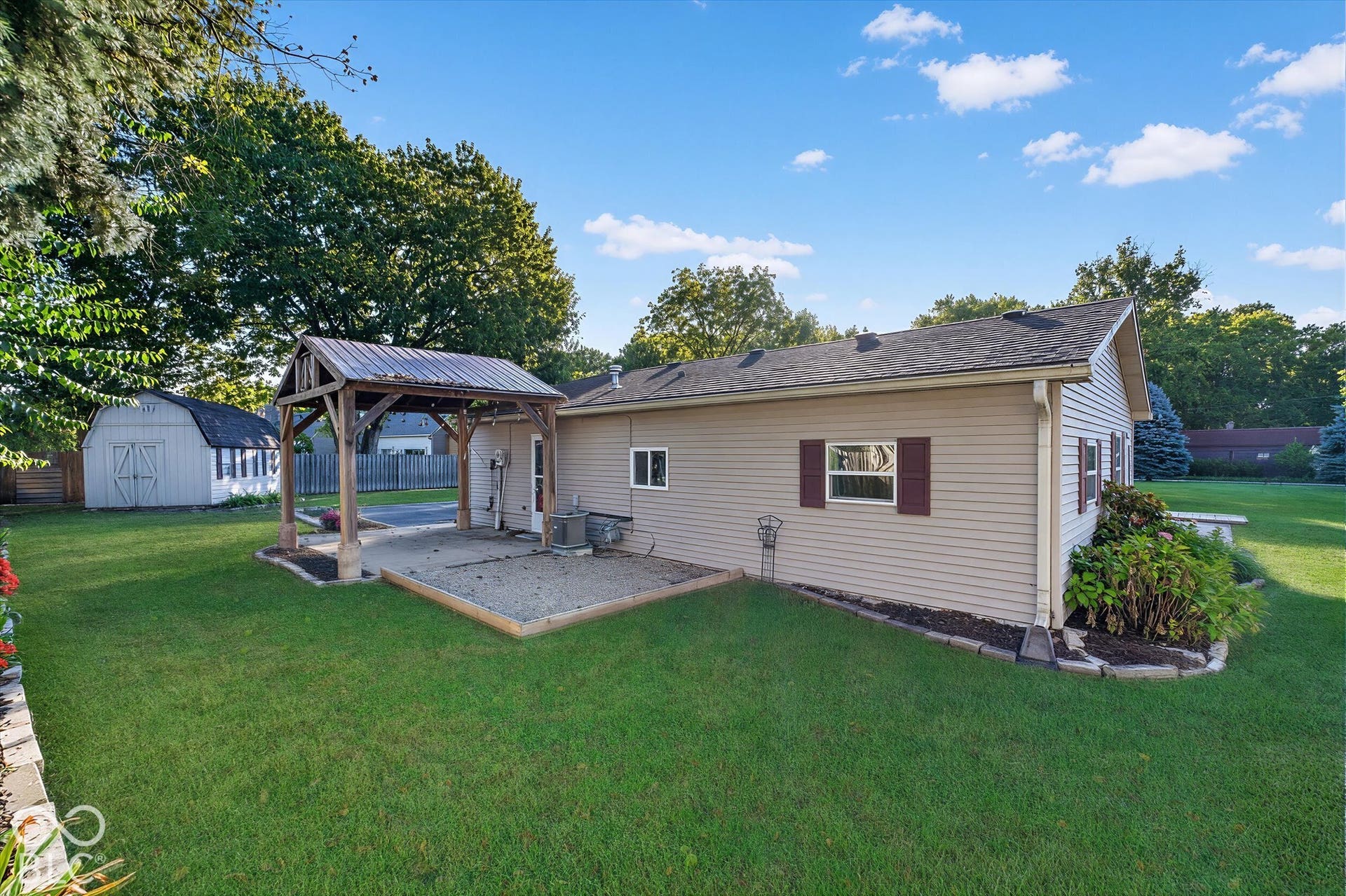 8404 Union Chapel Road, Indianapolis, IN 46240 8402: Expansive lawn, covered patio structure, gravel patio, detached storage shed, and mature trees
