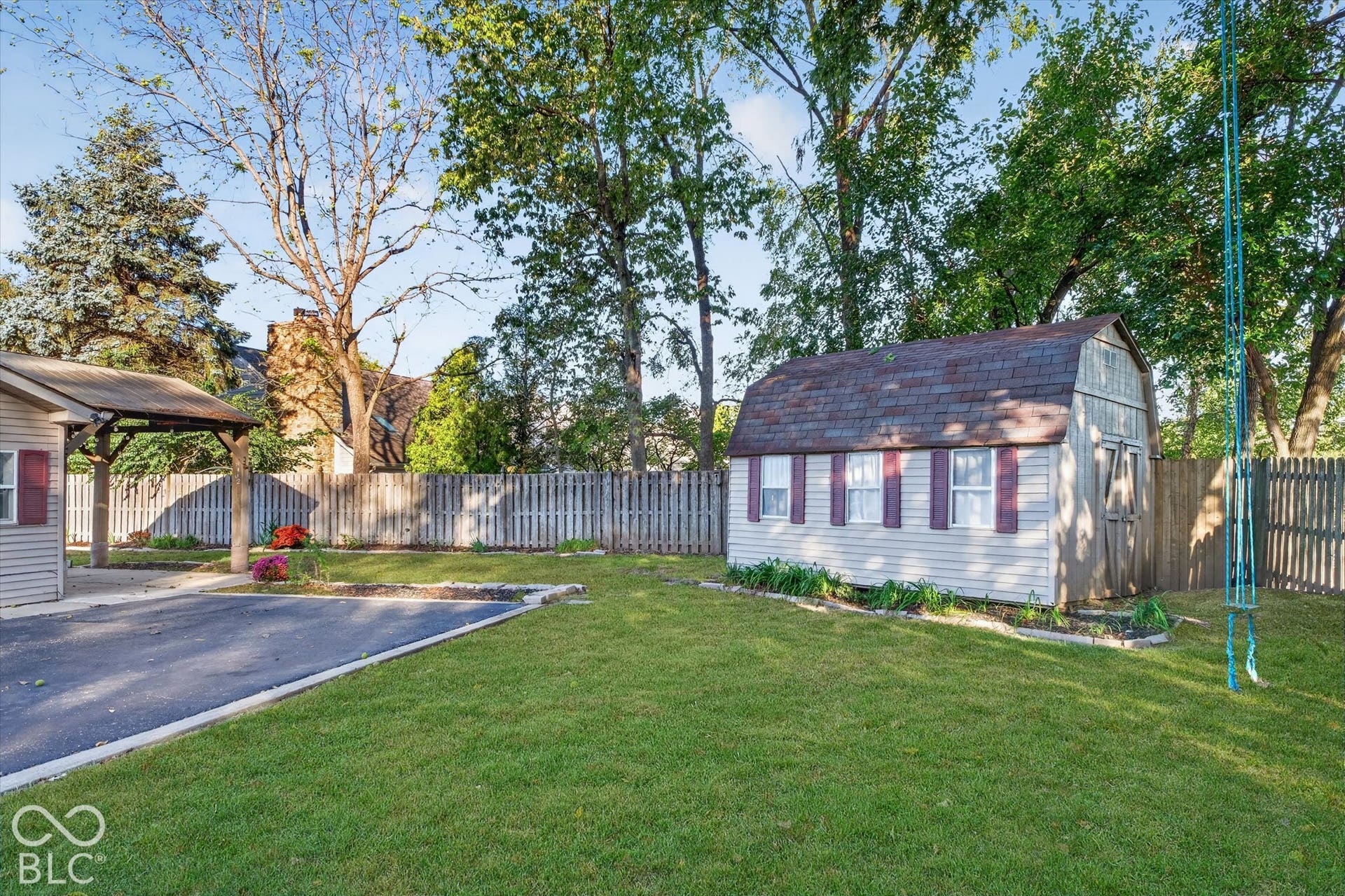 8404 Union Chapel Road, Indianapolis, IN 46240 Expansive green lawn, wood fence partial, and a detached storage shed with a barn-style roof