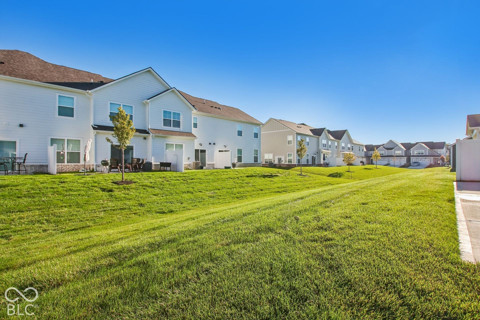 Expansive green space featuring mature landscaping and a concrete pathway