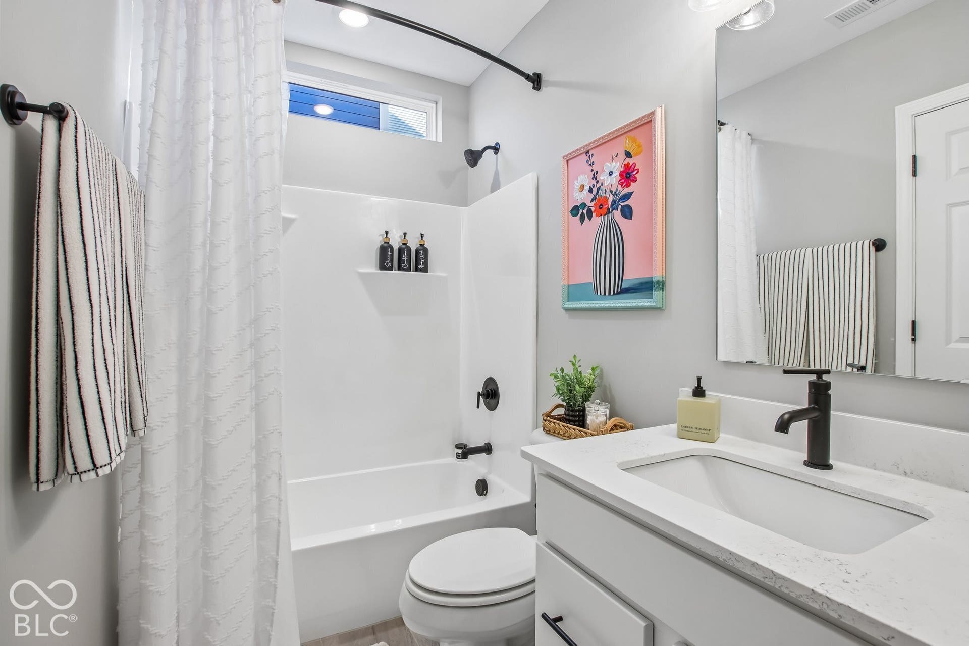 White vanity with an integrated rectangular sink and a single-handle matte black faucet