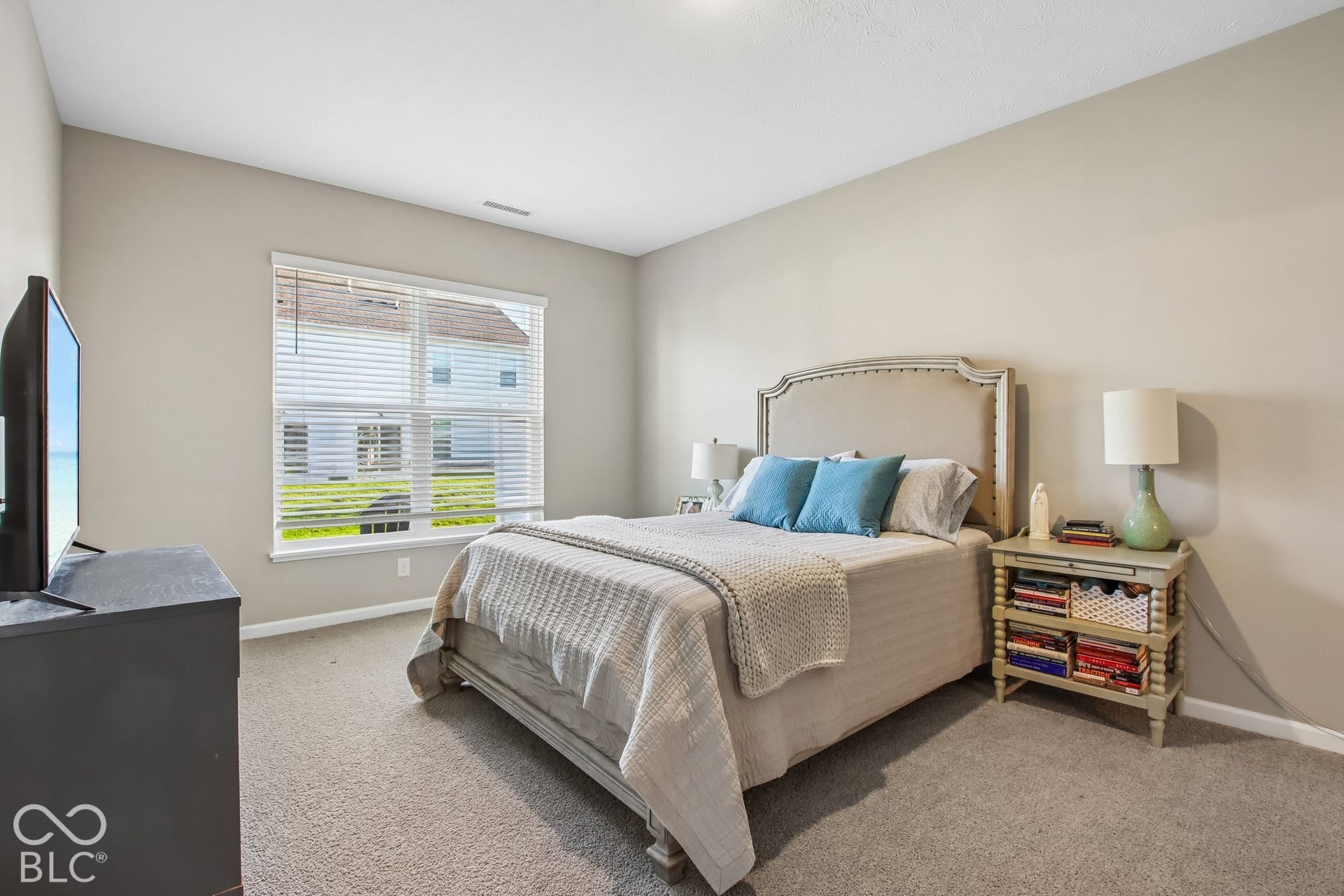 Carpeted flooring, neutral wall tones, window with horizontal blinds, and a built-in recessed light fixture