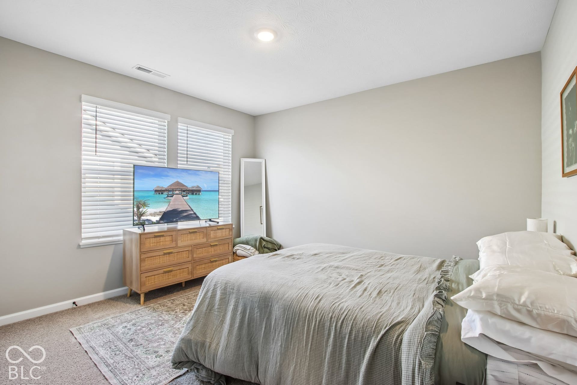 Recessed ceiling lighting, light gray wall paint, two windows with blinds, and textured carpeting