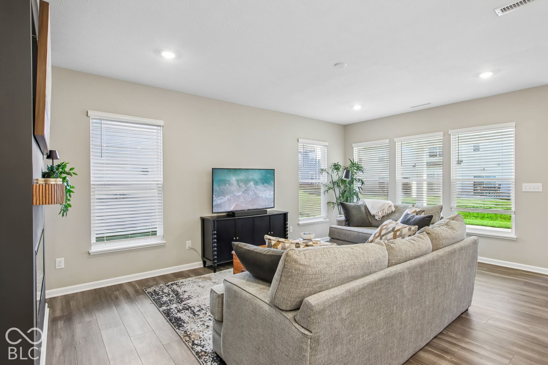 Living area featuring multiple windows, recessed lighting, and wood-finish flooring