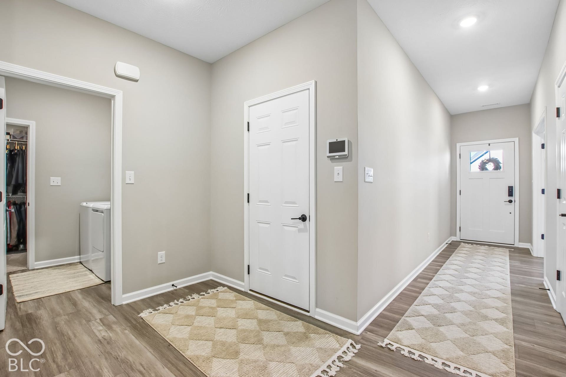 Recessed lighting and wood-finish flooring complement the neutral wall tones