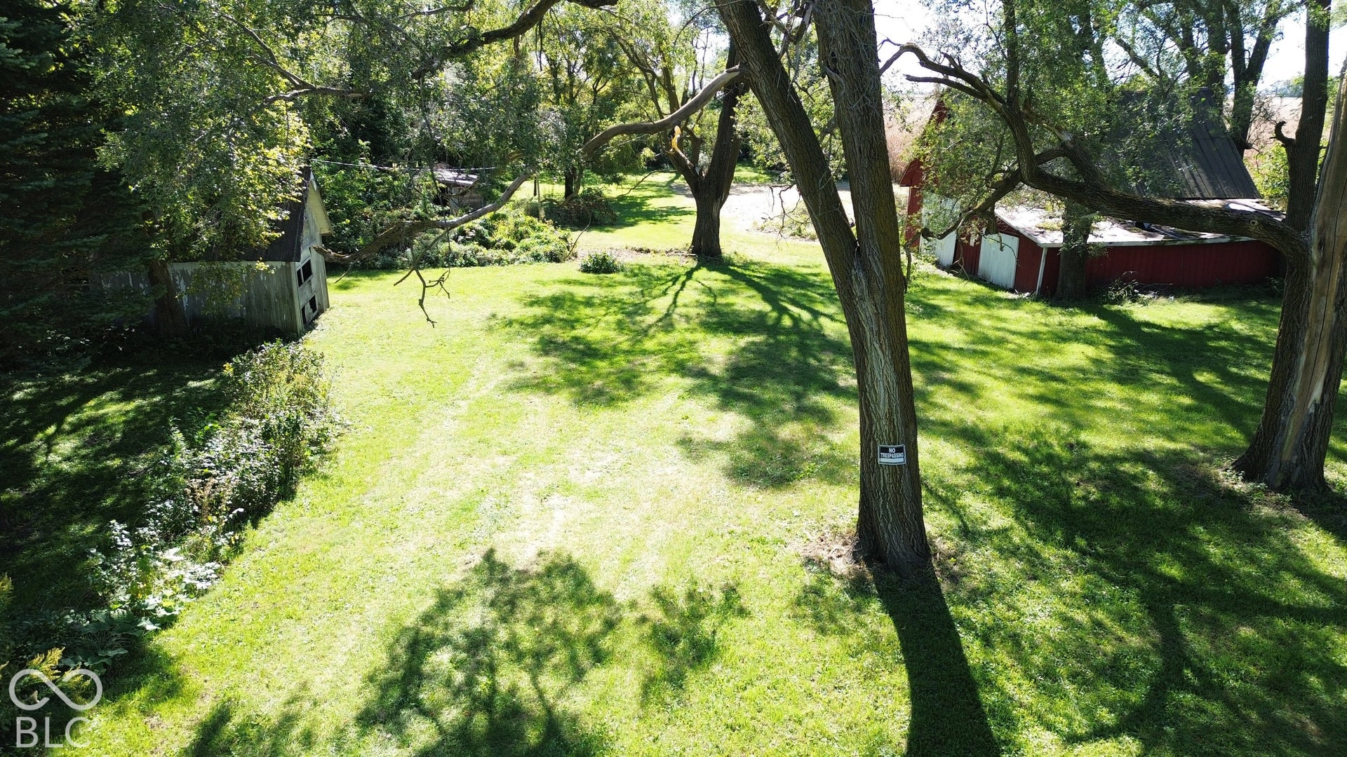 Barn lot and grassy grounds featuring mature trees