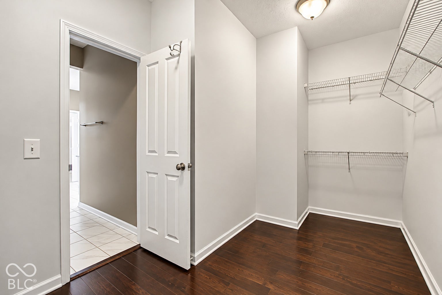 Spacious closet featuring wood-finish flooring and wire shelving