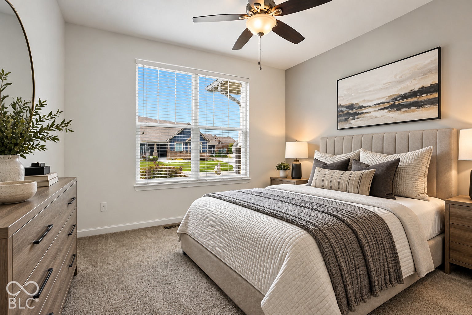 Light-filled room featuring a broad window, ceiling fan with integrated lighting, and neutral wall tones