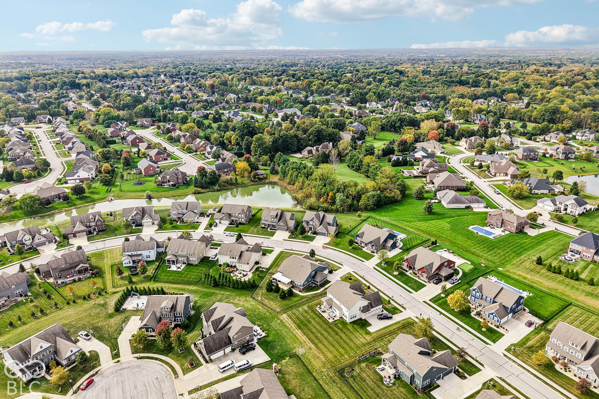 Residential neighborhood featuring a curvilinear street plan, established landscaping, and multiple properties with private swimming pools