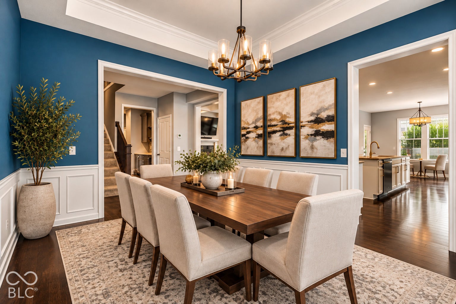 Tray ceiling with crown molding, wainscoting, dark wood-finish flooring, and a bronze-finish chandelier