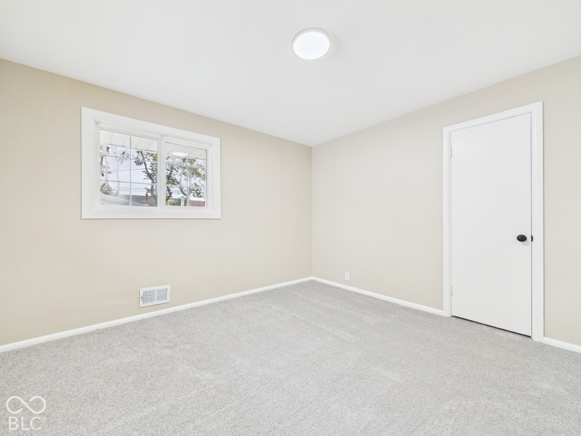 Neutral-toned walls complement light gray carpeting