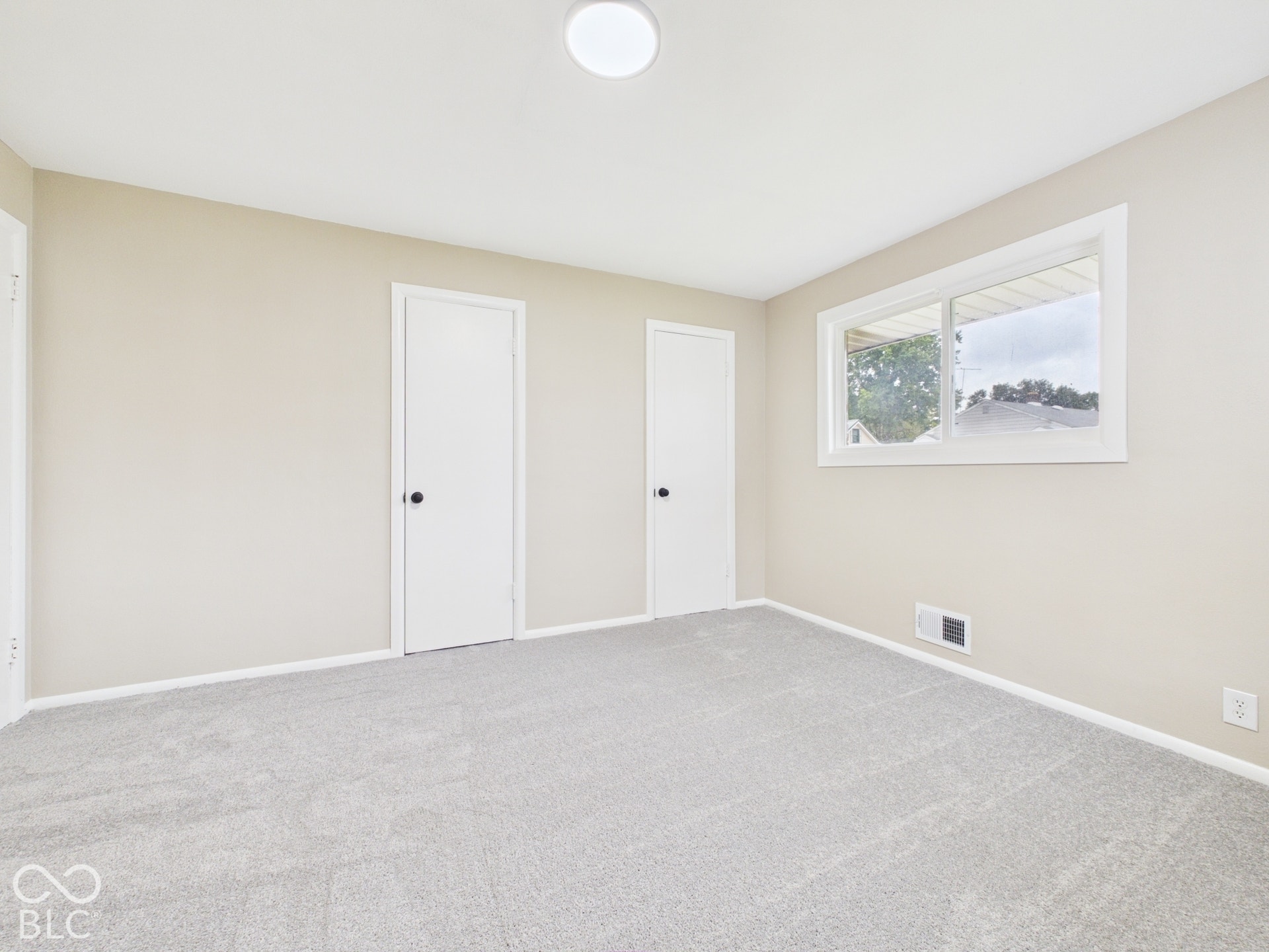 Neutral-toned walls complement the light gray carpet flooring