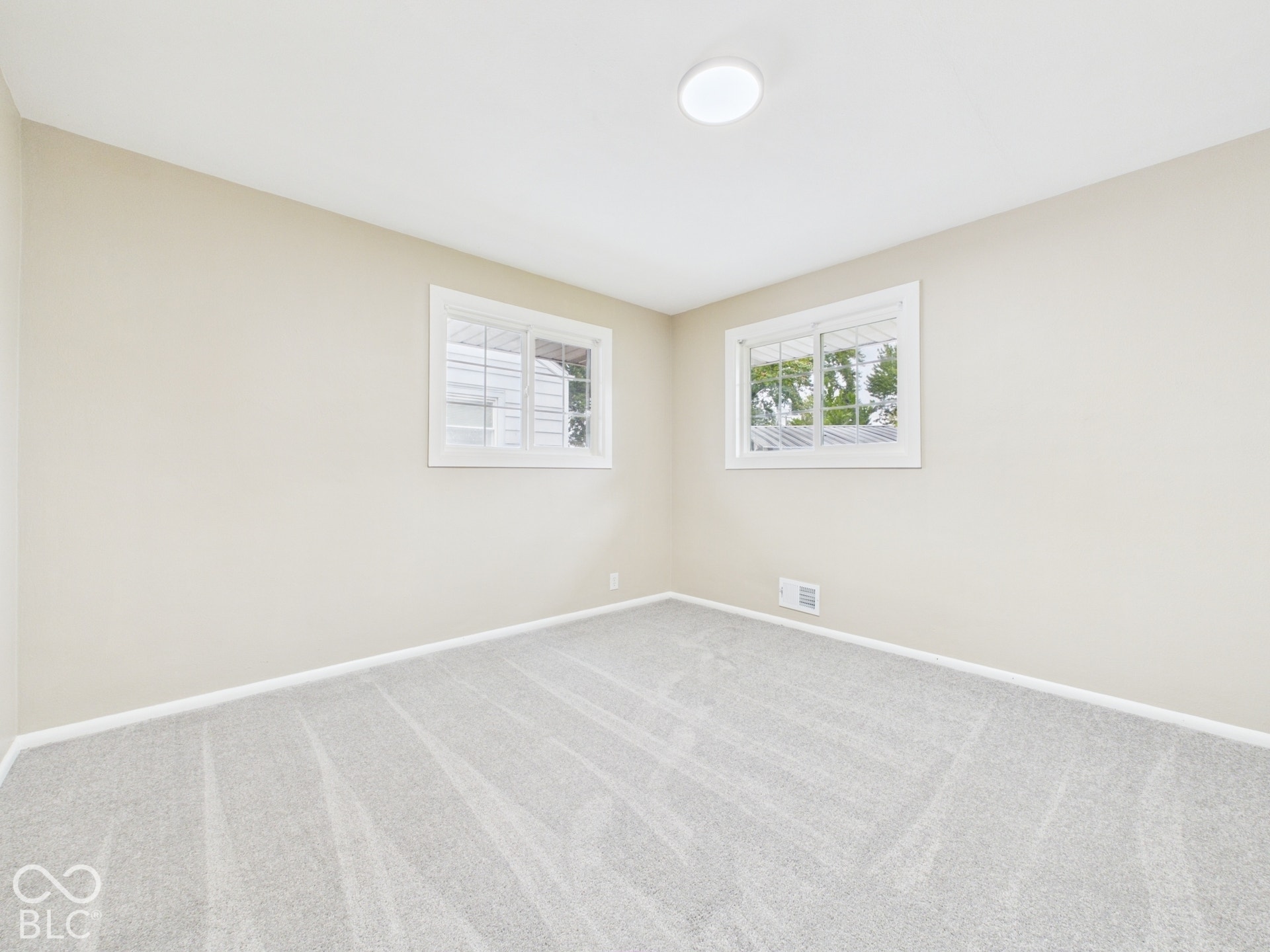Light-toned walls complement the fresh, light gray carpet