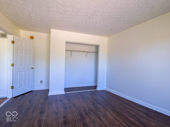 Wood-finish flooring, white walls, and a built-in closet with shelving and hanging rod
