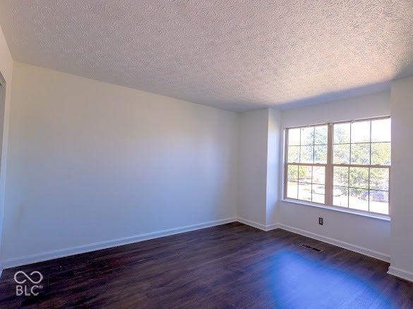 Wood-finish flooring with white baseboards, a large multi-pane window, and light-toned walls