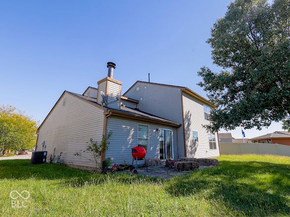 Patio with sliding glass door access, exterior siding, and a prominent chimney feature