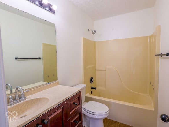 Vanity with integrated sink and storage cabinetry, full-width wall mirror, and an adjacent shower-tub combination