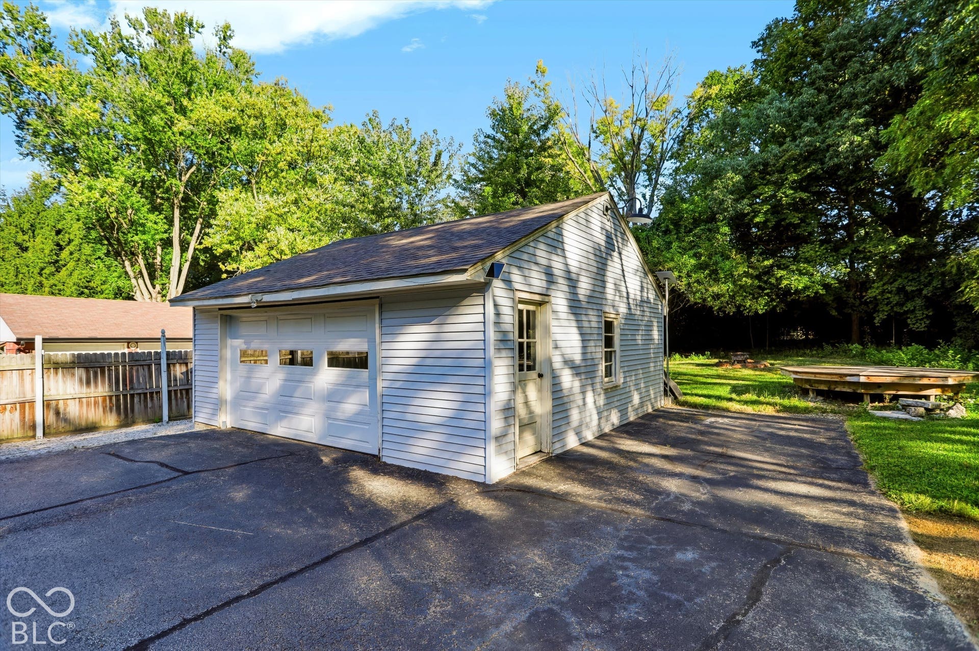 Detached garage with vinyl siding and an asphalt shingle roof