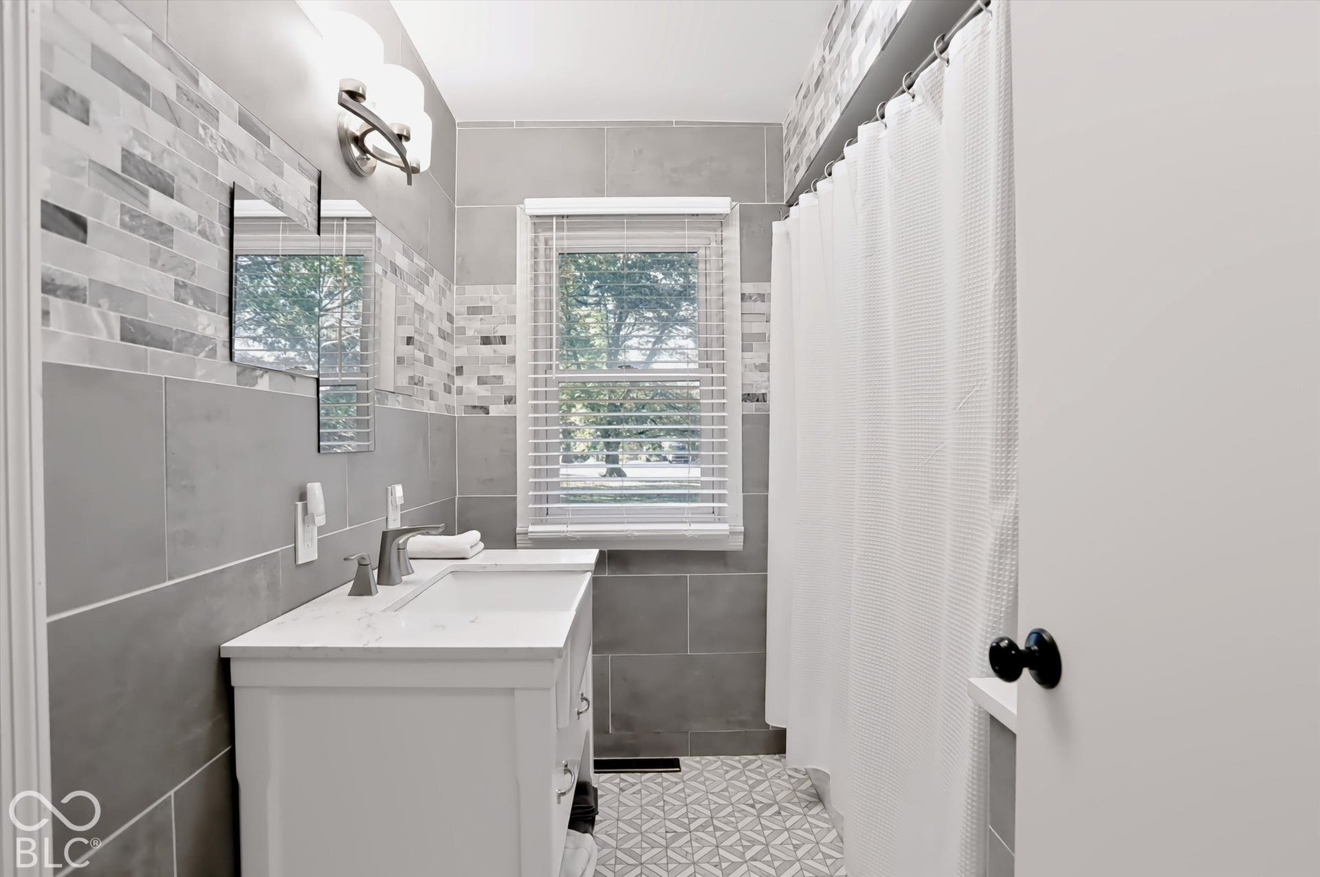 Vanity with integrated sink, brushed nickel faucet, and white countertop