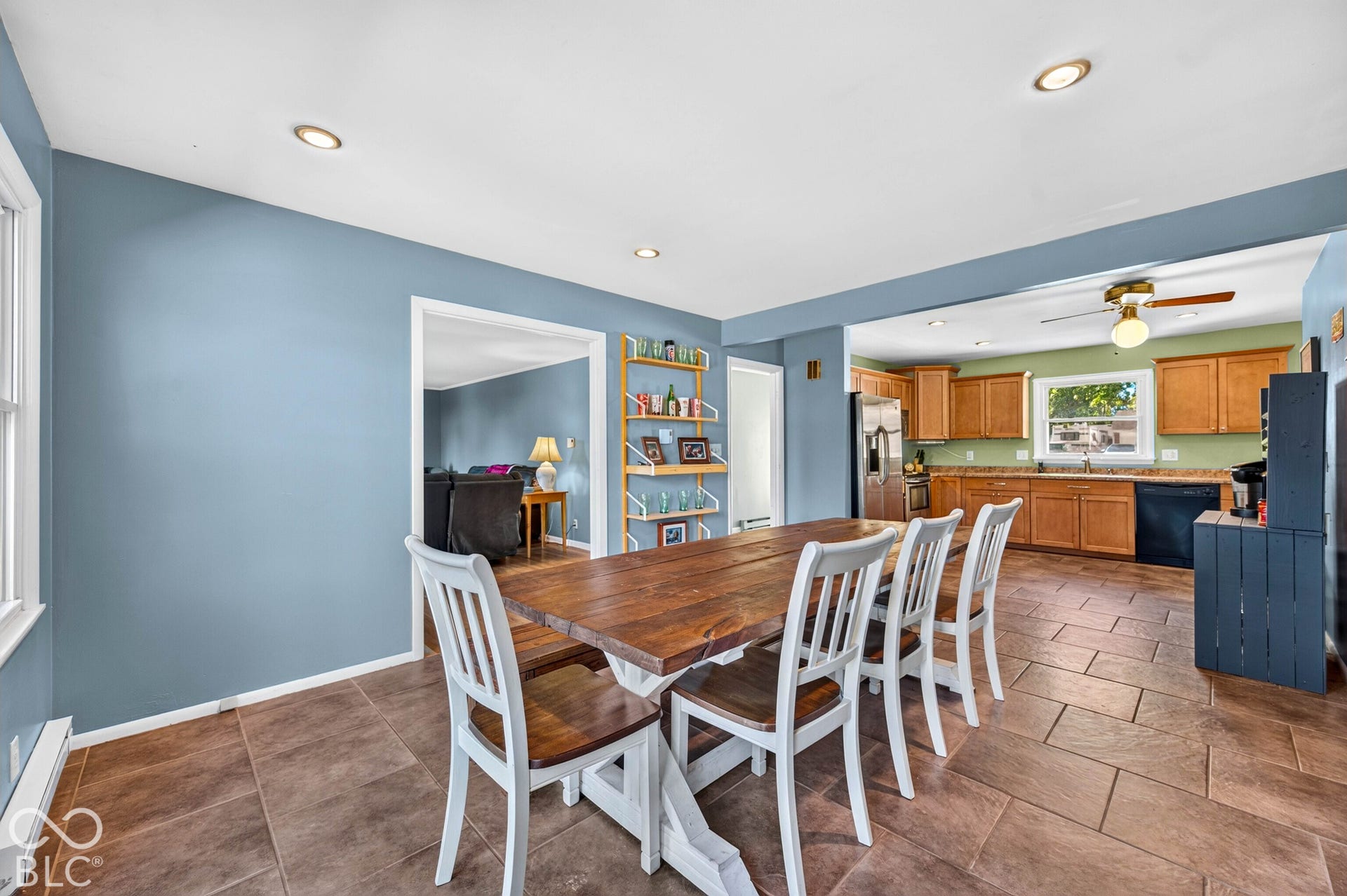 Recessed ceiling lighting, tiled flooring, wood cabinetry, and a stainless steel refrigerator