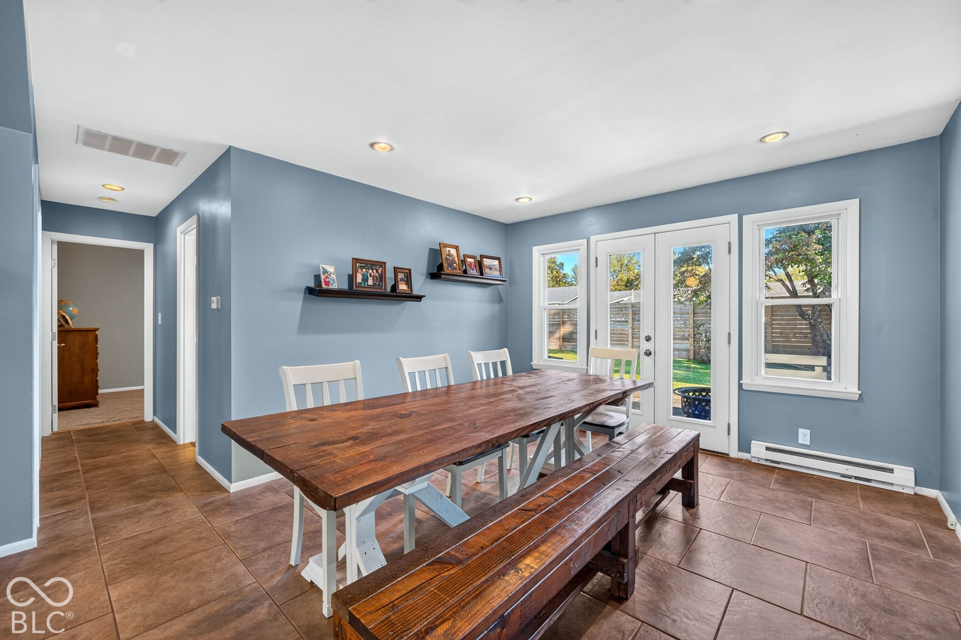 Terra cotta tile flooring, recessed ceiling lighting, and french doors with side windows
